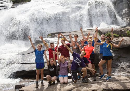 happy group in front of waterfall